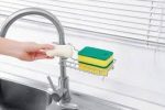 Multipurpose faucet rack attached to a kitchen sink, holding sponges, soap, and cleaning tools in Lagos Nigeria