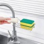 Multipurpose faucet rack attached to a kitchen sink, holding sponges, soap, and cleaning tools in Lagos Nigeria